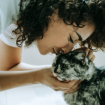 woman kissing cat, featured image for purrfect companions by ed carter